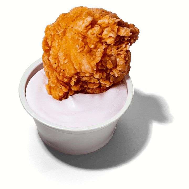 Pote de maionese de alho com um pedaço de frango empanado