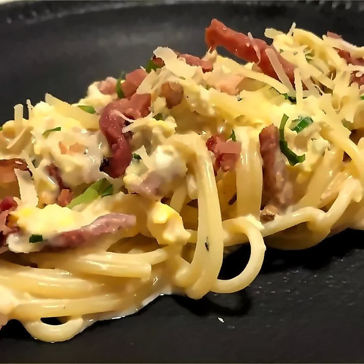 Espaguete com bacon e queijo ralado, em prato preto